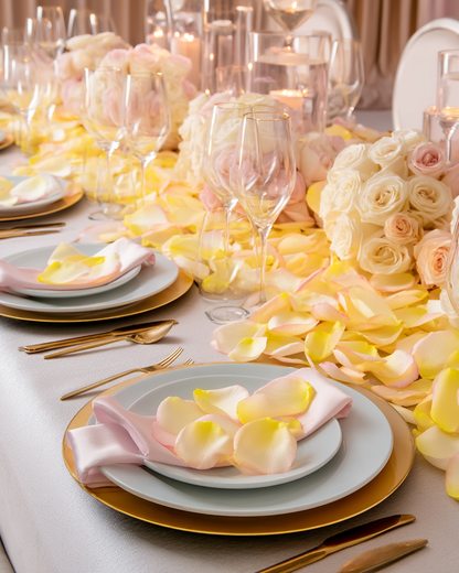 Table de mariage dorée décorée de pétales de rose jaune-rose, roses crème et couverts dorés | The Originea