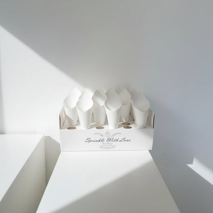 Lot de cônes à confettis en papier présentés dans un présentoir, mise en situation mariage | The Originea