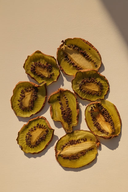 Tranches réelles de kiwi séché au cœur graphique étoilé, chair verte et graines noires au soleil | The Originea