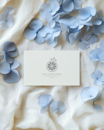 Pétales d'hortensias bleu clair séchés sur lin ivoire avec carte The Originea — confettis mariage naturels