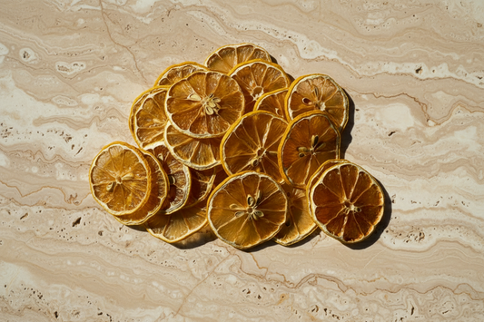 Tranches de citron jaune séchées — vue de la main tenant une belle sélection dorée | The Originea