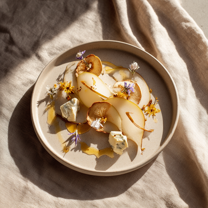 Assiette gastronomique avec tranches de poire fraîche, chips de poires séchées, fromage bleu et fleurs comestibles — The Originea