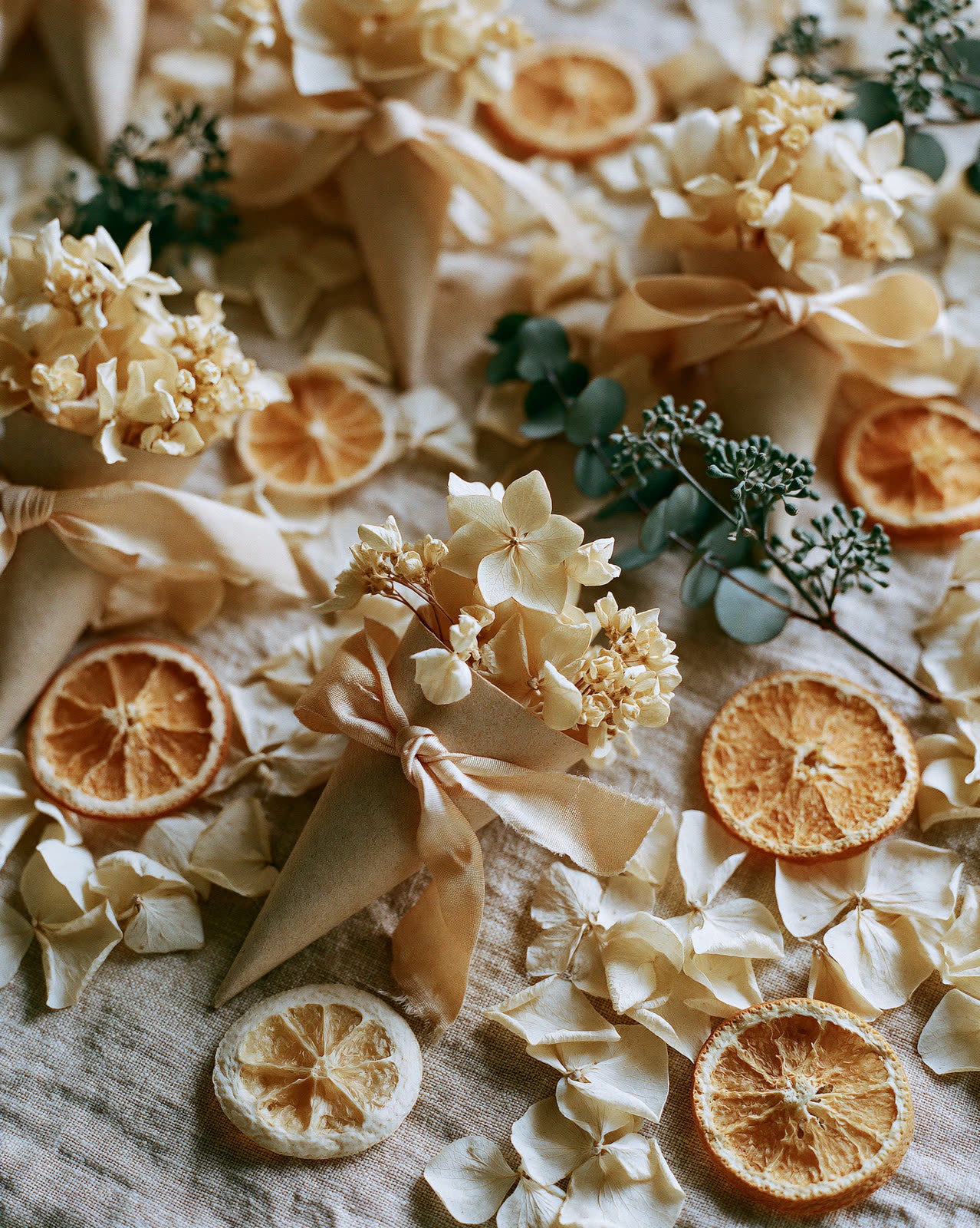 Cônes de confettis en hortensia blanc séché, tranches d'orange et eucalyptus — décoration de mariage The Originea